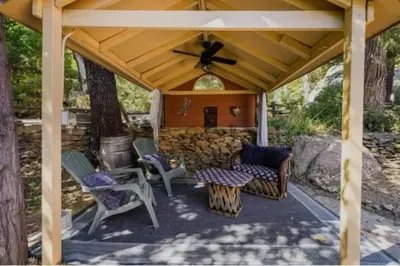 a patio with chairs and a ceiling fan at Cozy Cabin Hot Tub Sauna Fireplace in Palomar Mountain