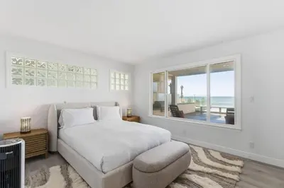 a white bedroom with a bed and a window at Sea Glass Beach Road Villa On the SAND Luxury and relaxation in Dana Point
