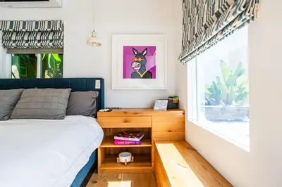 a bedroom with a bed and a night stand next to a window at Simple La Jolla Epic bungalow # 3 in San Diego
