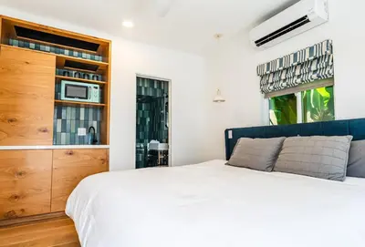 a bedroom with a white bed and a wooden cabinet at Simple La Jolla Epic bungalow # 3 in San Diego