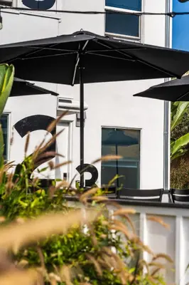 a table with an umbrella in front of a building at Simple La Jolla Epic bungalow # 3 in San Diego