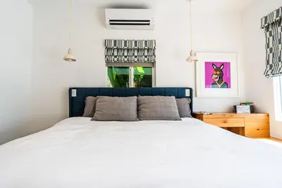 a bedroom with a white bed and a fish tank at Simple La Jolla Epic bungalow # 3 in San Diego