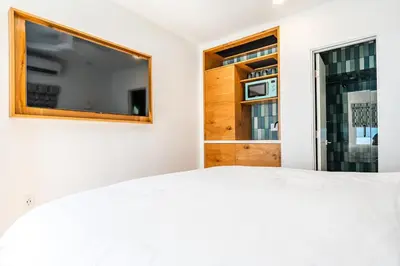 a bedroom with a flat screen tv and a bed at Simple La Jolla Epic bungalow # 3 in San Diego