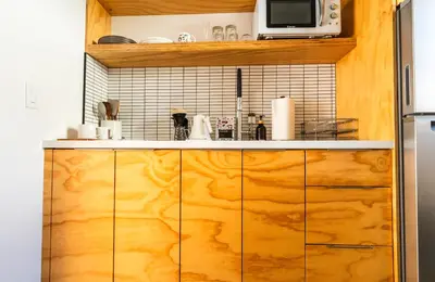 a kitchen with wooden cabinets and a microwave at Simple La Jolla Epic bungalow # 2 in San Diego