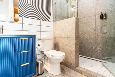 a bathroom with a toilet and a glass shower at Simple La Jolla Epic bungalow # 2 in San Diego