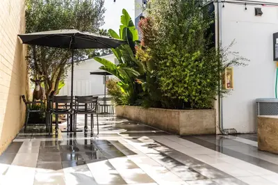 a patio with tables and an umbrella on a tile floor at Simple La Jolla Epic bungalow #7 in San Diego