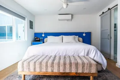 a bedroom with a large bed with a blue headboard at Simple La Jolla Epic bungalow #7 in San Diego