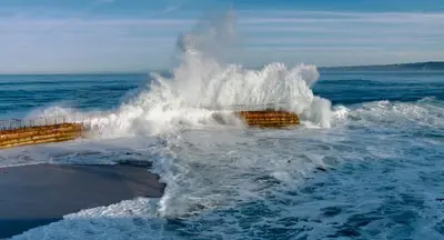 a wave crashing on a pier in the ocean at Amazing La Jolla Ocean View 2 bedroom apartment in San Diego