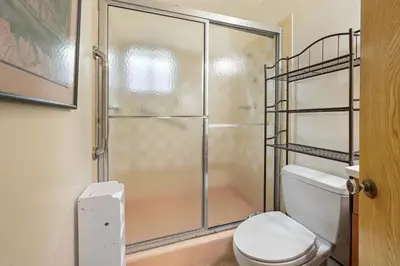 a bathroom with a toilet and a glass shower at Private Spacious Full Bed Studio in San Diego