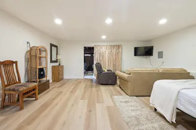 a large living room with a couch and a tv at Private Spacious Full Bed Studio in San Diego