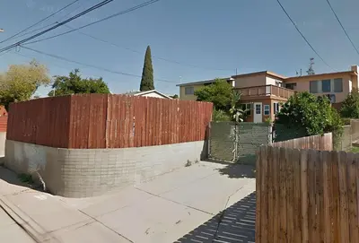 a fence next to a sidewalk next to a house at Private Spacious Full Bed Studio in San Diego