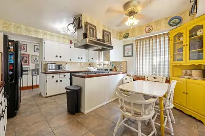 a kitchen with yellow cabinets and a table in it at Stay at Grandmas Entire Home with Yard & Balcony in San Diego