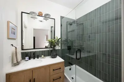 a bathroom with a sink and a shower with a mirror at Newport Coast Bungalow in Newport Beach