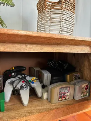 two video game controllers sitting on a wooden shelf at Charming 1 Bedroom Home with Hot Tub & Bonus Room! in San Diego