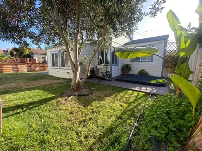 a house with a tree in the yard at Charming 1 Bedroom Home with Hot Tub & Bonus Room! in San Diego