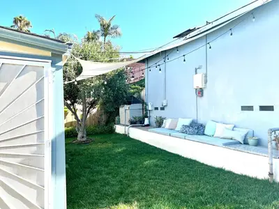 a white house with a couch in the yard at Charming 1 Bedroom Home with Hot Tub & Bonus Room! in San Diego