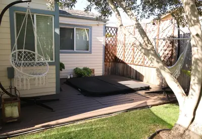 a hammock on a deck next to a house at Charming 1 Bedroom Home with Hot Tub & Bonus Room! in San Diego
