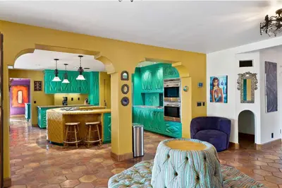 a kitchen with green cabinets and a table in a room at Skyline and Bay Views Spanish Villa Pool and Hot Tub in San Diego