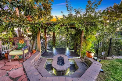 a backyard with a fire pit and a fence at Skyline and Bay Views Spanish Villa Pool and Hot Tub in San Diego