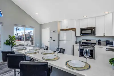 a kitchen with a table with plates and wine glasses at Walk to Ocean Beach Stylish 2BR Apt with Patio in San Diego