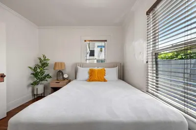 a white bedroom with a large bed and a window at Mid-City 2BR Retreat Firepit Nights with Free Parking in San Diego