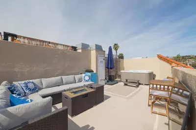 a living room with a couch and a table on a patio at Surfing SapphirePrivate Rooftop Hot Tub wFirepit in San Diego