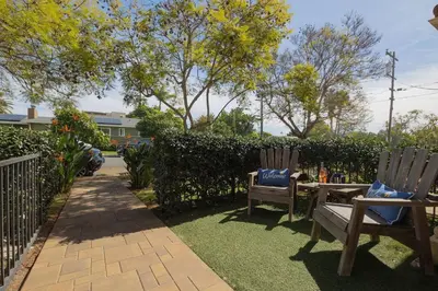 two chairs sitting on the grass near a fence at Surfing SapphirePrivate Rooftop Hot Tub wFirepit in San Diego