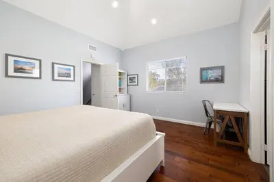 a white bedroom with a bed and a desk at Surfing SapphirePrivate Rooftop Hot Tub wFirepit in San Diego