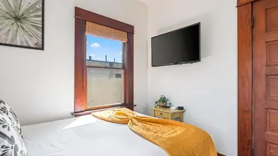 a bedroom with a bed with a window and a tv at 2 Side-by-Side San Diego Homes w Shared Backyard Firepit BBQ Casa Craftsman Casita on Landis by Avantstay in San Diego