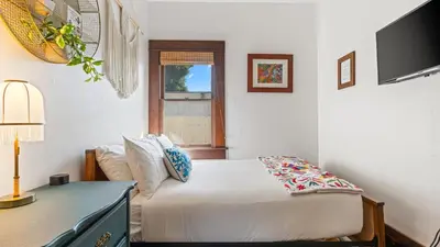a bedroom with a bed and a desk and a television at 2 Side-by-Side San Diego Homes w Shared Backyard Firepit BBQ Casa Craftsman Casita on Landis by Avantstay in San Diego