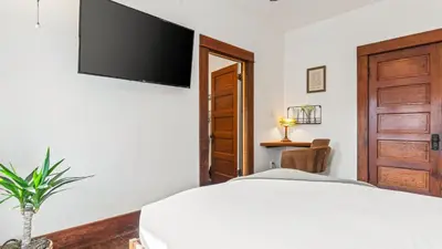 a bedroom with a bed and a television on the wall at 2 Side-by-Side San Diego Homes w Shared Backyard Firepit BBQ Casa Craftsman Casita on Landis by Avantstay in San Diego