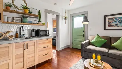 a kitchen and living room with a couch and a table at 2 Side-by-Side San Diego Homes w Shared Backyard Firepit BBQ Casa Craftsman Casita on Landis by Avantstay in San Diego