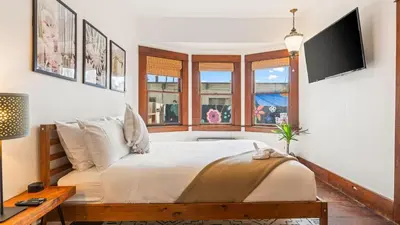 a bedroom with a bed and a tv on the wall at 2 Side-by-Side San Diego Homes w Shared Backyard Firepit BBQ Casa Craftsman Casita on Landis by Avantstay in San Diego