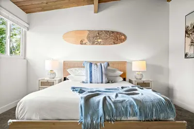 a bedroom with a large bed with a wooden headboard at Spacious 4BR Retreat with Hot Tub Fire Pit and Patio in San Diego