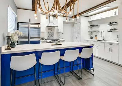 a kitchen with a blue and white island with stools at Spacious Family Getaway with Grill Firepit and Patio in San Diego