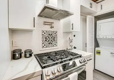 a white kitchen with a stove top oven at Spacious Family Getaway with Grill Firepit and Patio in San Diego