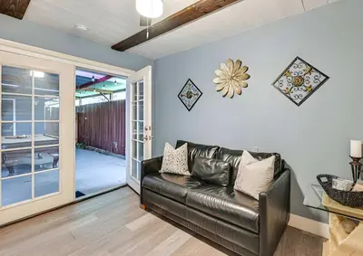 a living room with a leather couch and a sliding glass door at Spacious Family Getaway with Grill Firepit and Patio in San Diego
