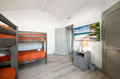 a bedroom with two bunk beds and a tv at Walk to beach Prime location Villa in San Diego