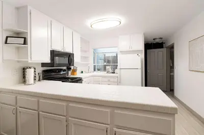 a kitchen with white cabinets and a white counter top at Walk to Beach Walk to hot spots Villa in San Diego