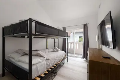 a bedroom with a bunk bed and a television at Steps to beach Best Location Villa in San Diego