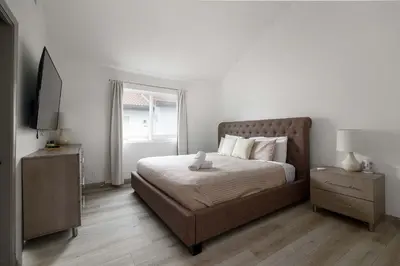 a bedroom with a bed and a television in it at Steps to beach Best Location Villa in San Diego