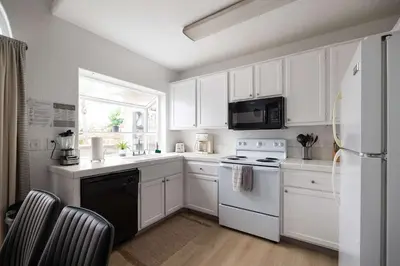 a kitchen with white cabinets and a white refrigerator at Steps tp beach Prime location Villa in San Diego
