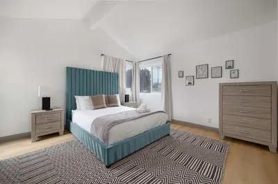 a bedroom with a bed with a blue headboard and a rug at Steps tp beach Prime location Villa in San Diego
