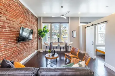 a living room with a couch and a brick wall at Gaslamp 2BR Upscale Queen Beds with Smart TV in San Diego
