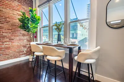 a dining room with a table and chairs in front of a window at Gaslamp 2BR Upscale Queen Beds with Smart TV in San Diego