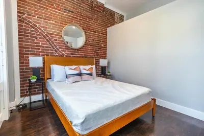 a bed in a room with a brick wall at Gaslamp 2BR Upscale Queen Beds with Smart TV in San Diego