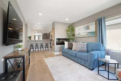 a living room with a blue couch and a kitchen at Central Location Gym Hot Tub Villa in San Diego
