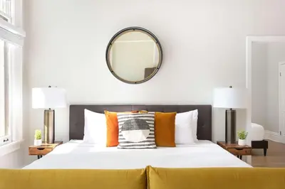 a bedroom with a large bed with a mirror on the wall at Gaslamp Loft Escape Sleeps 7 in Style in San Diego