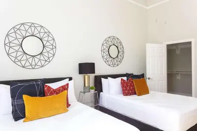 two beds in a bedroom with mirrors on the wall at Gaslamp Loft Escape Sleeps 7 in Style in San Diego