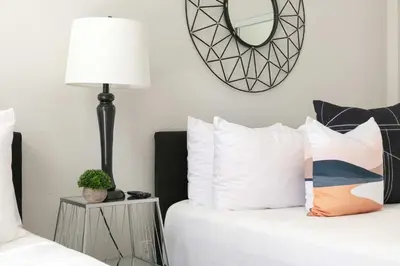 a bedroom with two beds with a lamp and a mirror at Bright 2BR Loft Sleeps 7 with Full Kitchen and Fast WiFi in San Diego